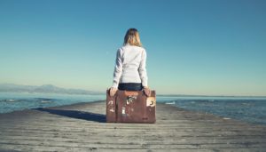 Disguidi in vacanza, una ragazza seduta sul molo deserto