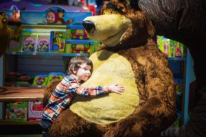 bambino con maxi orso giocattolo